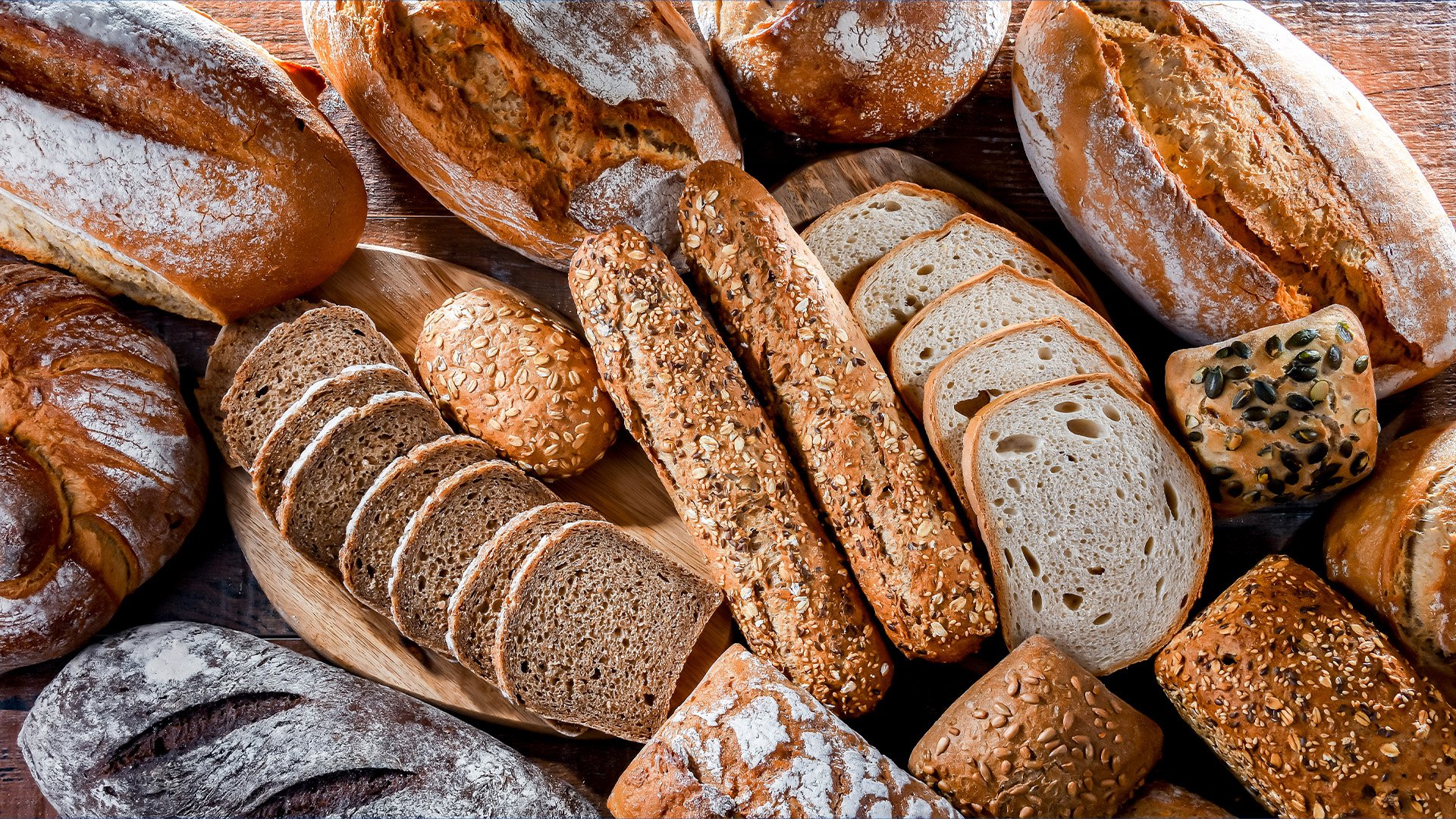 Different kinds freshly baked bread displayed on a table