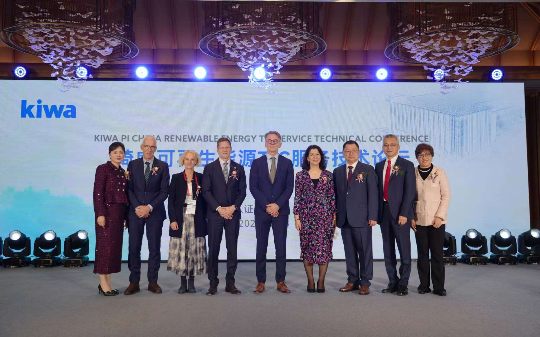 Group of people at Kiwa PI China Renewable Energy Conference on stage with a branded backdrop
