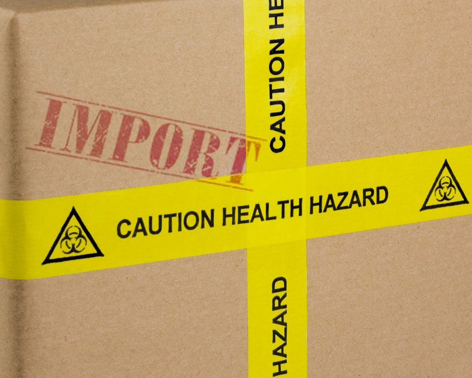 En förpackning i kartong, med fokus på en gul tejp med varningstext. 