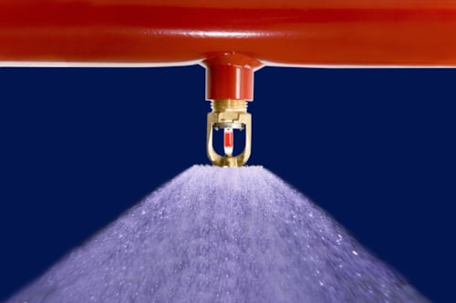 Närbild på en sprinkler som sprutar vatten.