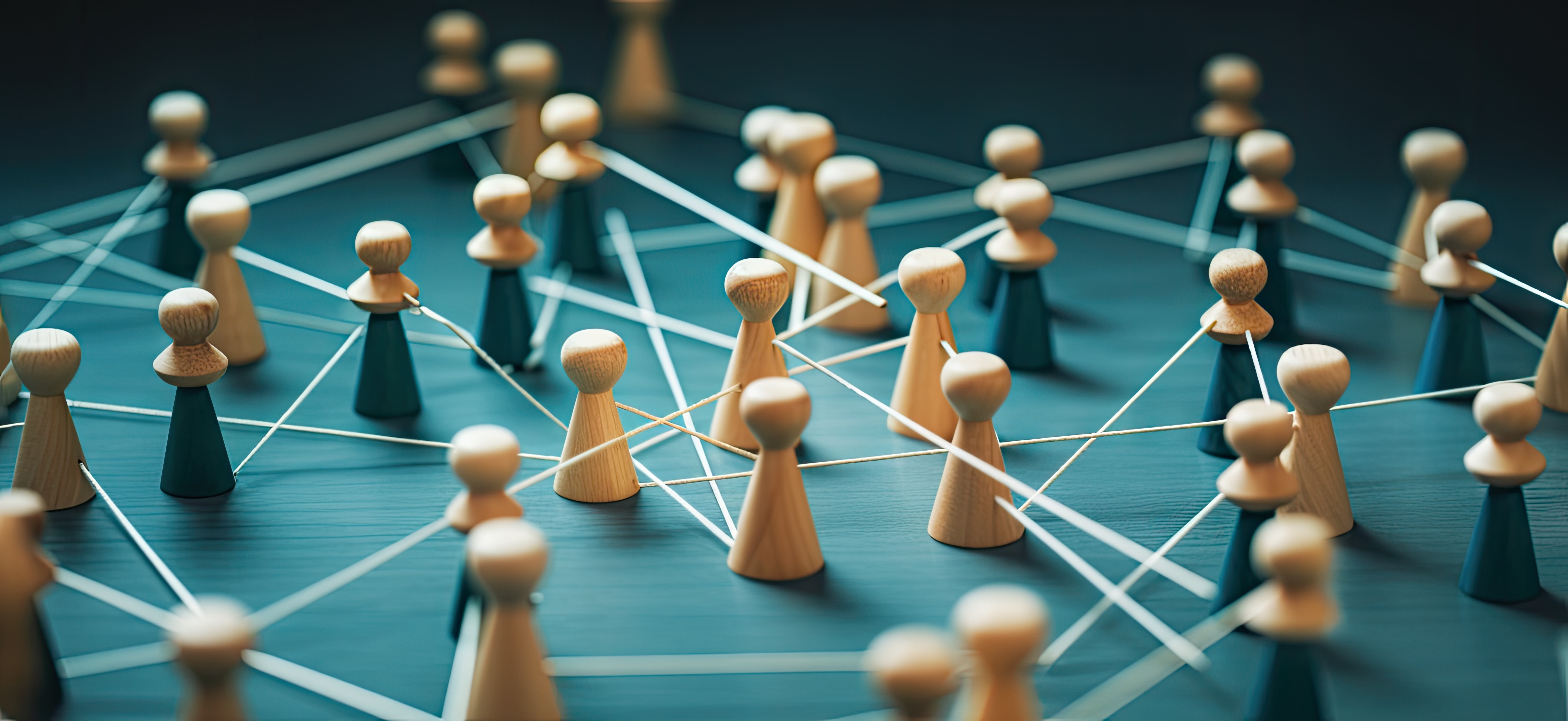 Figuras de madera conectadas por líneas blancas, representando una red o conexión.