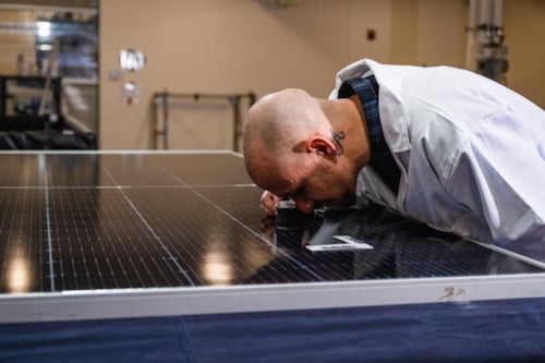 kiwa employee conducting a close-up indoor module investigation on an solar panel