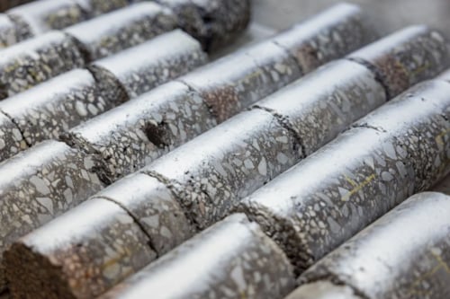 Rijen cilindrische betonmonsters met zichtbare aggregaatstructuur.