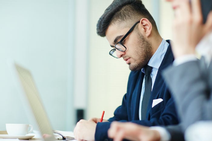 Man with glasses working on his laptop