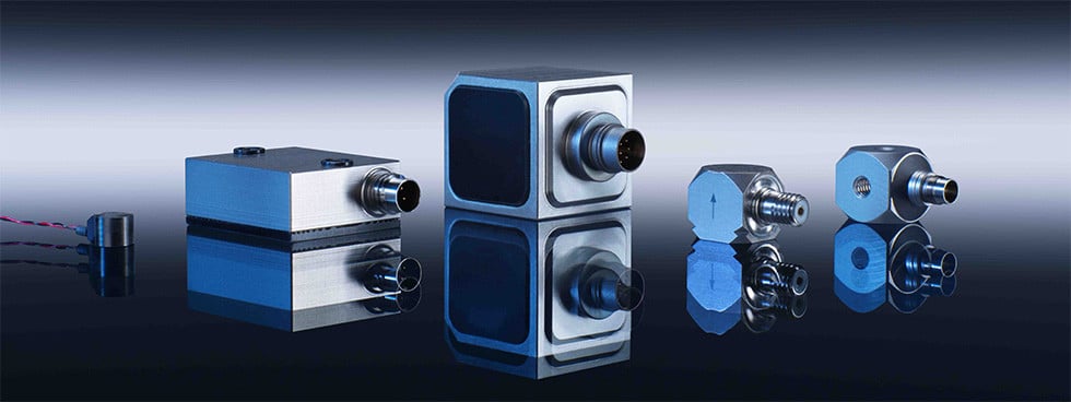 Various calibration instruments with connectors on a reflective surface, showcasing metallic finishes and different shapes, emphasizing precision engineering and technology.