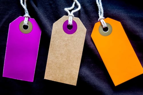 Blanka och tomma pappersetiketter i olika färger med ett knytsnöre, för märkning eller som pristaggar för produkter.